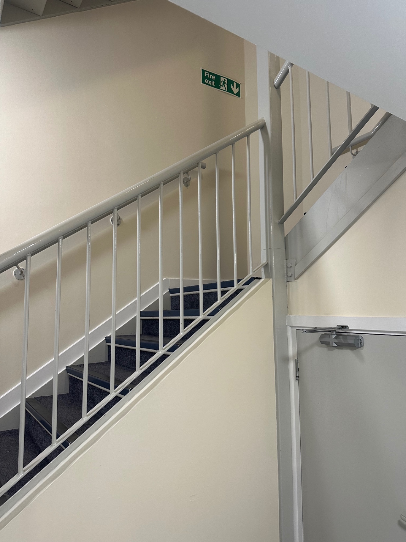 Repainted stairwell balustrades, spindles and fire exit signage in communal apartment block