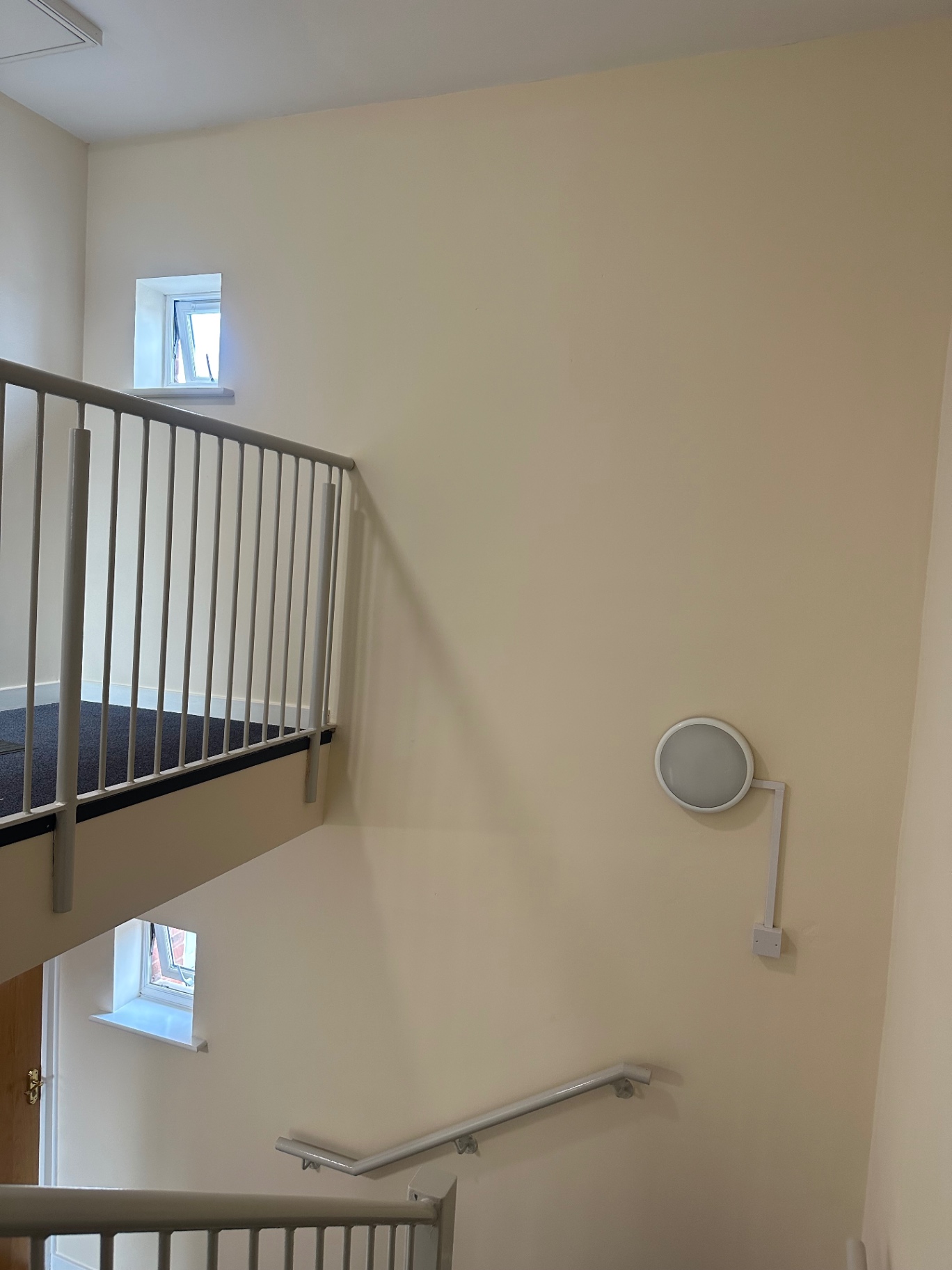 Upper stairwell landing with newly painted walls, ceilings and metal balustrades