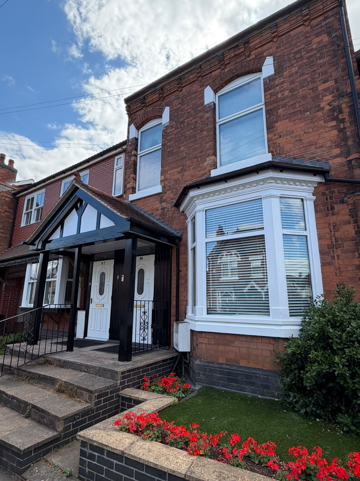 Bay Window & Porch Finished Finished Victorian bay window painted white beside a black and white timber porch on a red brick terrace