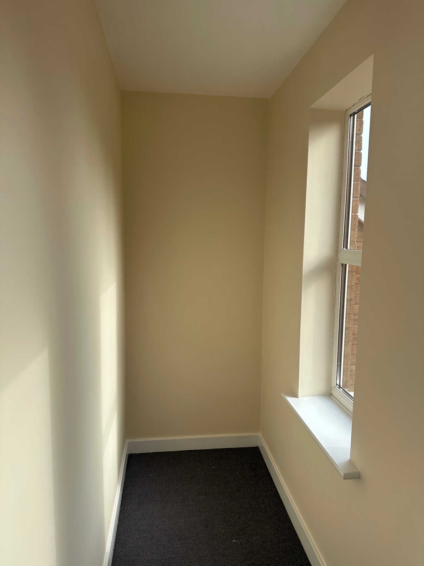 Small communal landing repainted with clean cream walls and white window reveal
