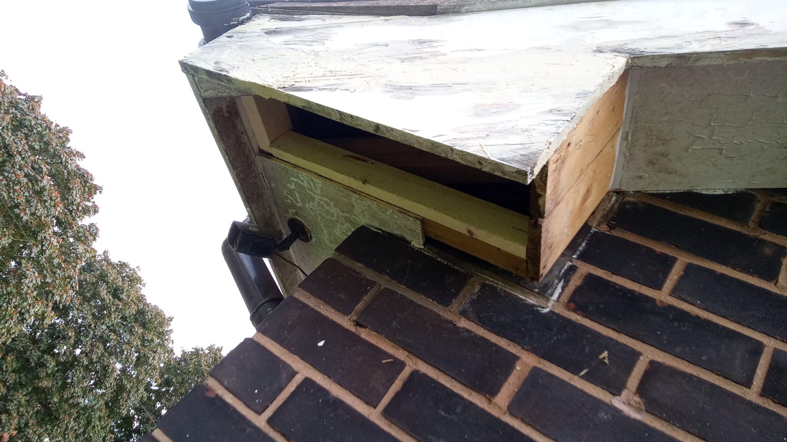 Rotten timber cut out at a roofline corner at Sutton Court