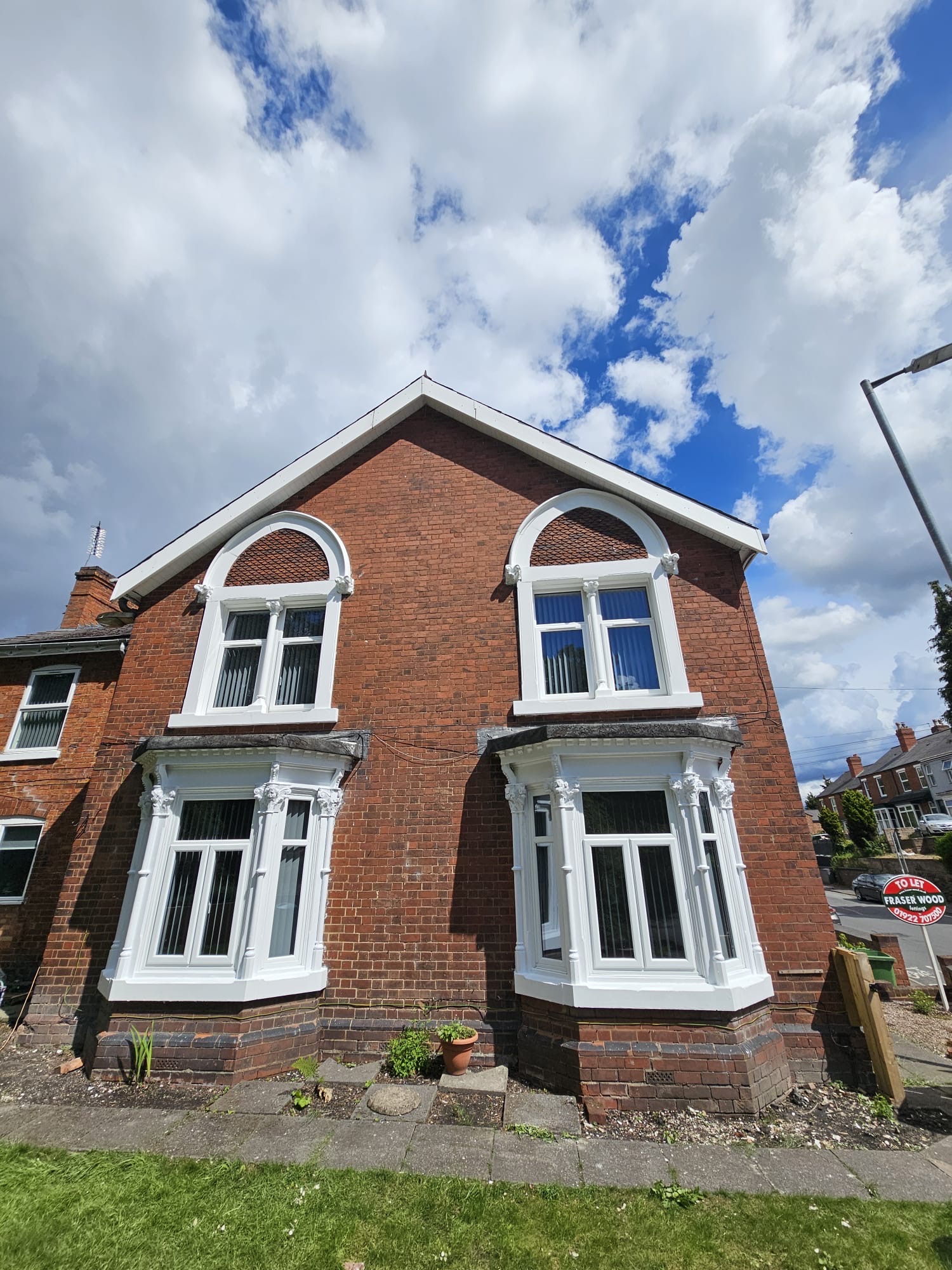 Victorian Bay Windows & Stonework Victorian red brick house with twin bay windows, arched window heads and decorative corbels freshly painted in white